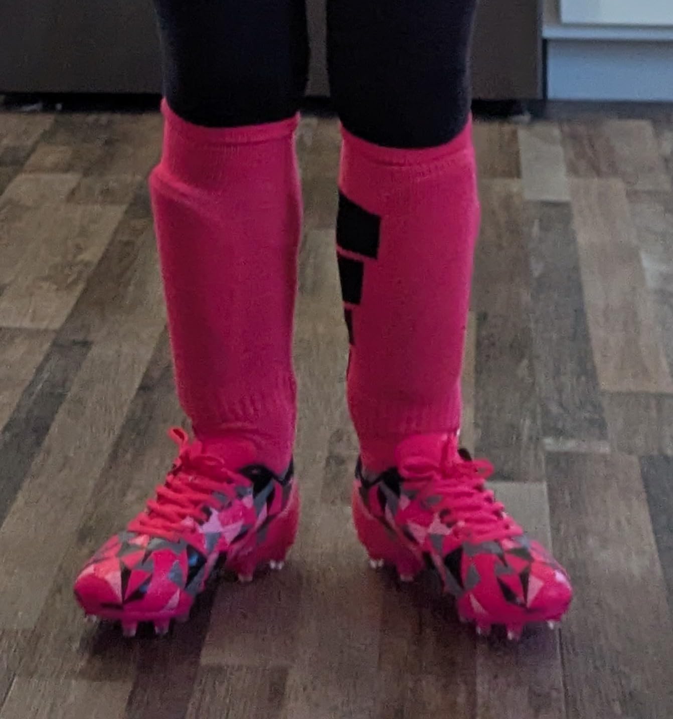 A young girl wearing the MIFAWA soccer cleats on a grassy field