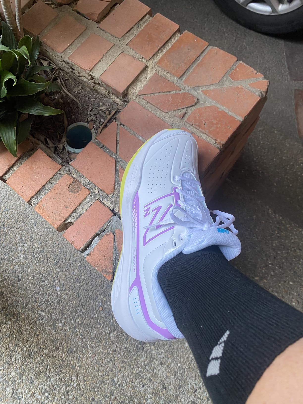 A woman on a tennis court, ready to play in her New Balance 696v5 shoes