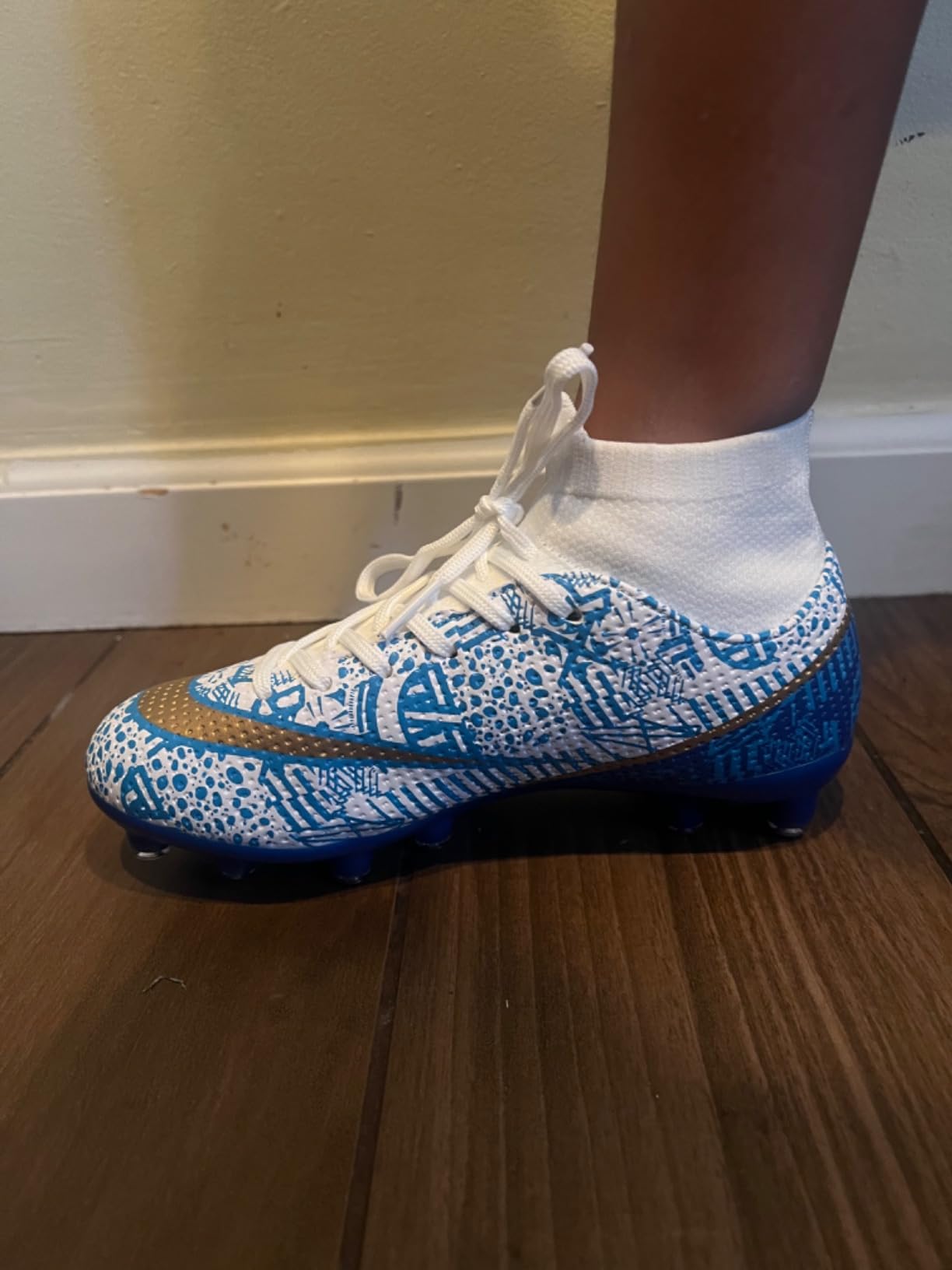 Close up view of kids soccer cleats showing TPU cleat pattern and synthetic upper construction