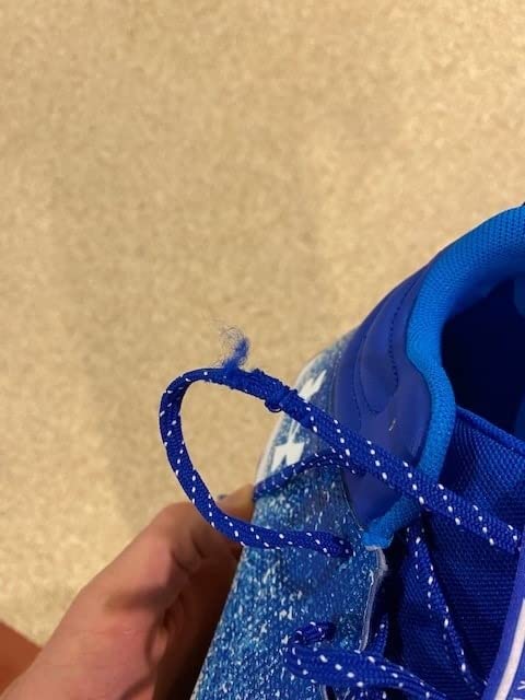 Detailed view of Under Armour Spotlight cleat sole showing molded rubber cleat pattern and EVA midsole construction