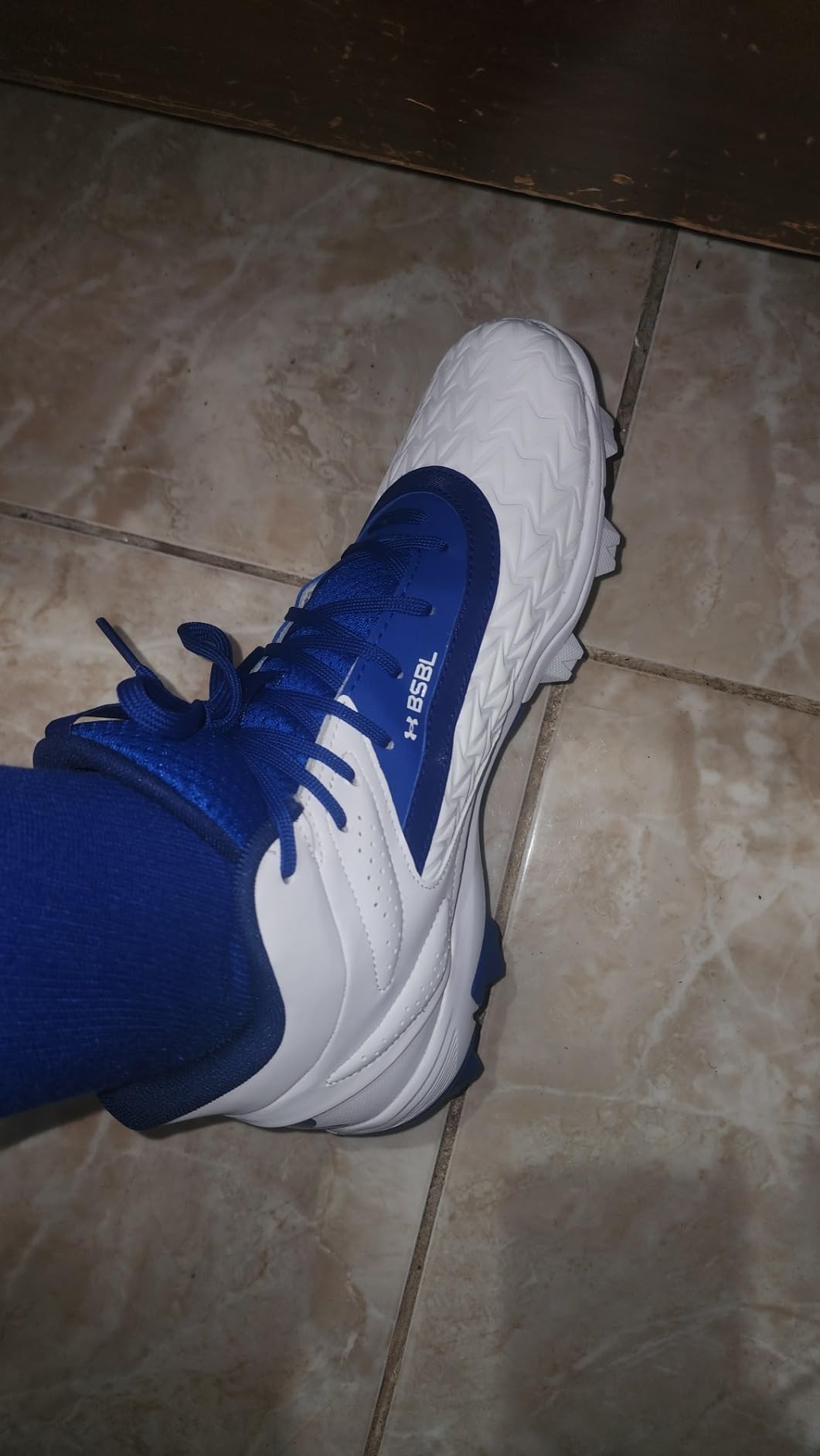 Under Armour Leadoff Mid 3.0 cleats on baseball field showing molded rubber cleat configuration and traction pattern