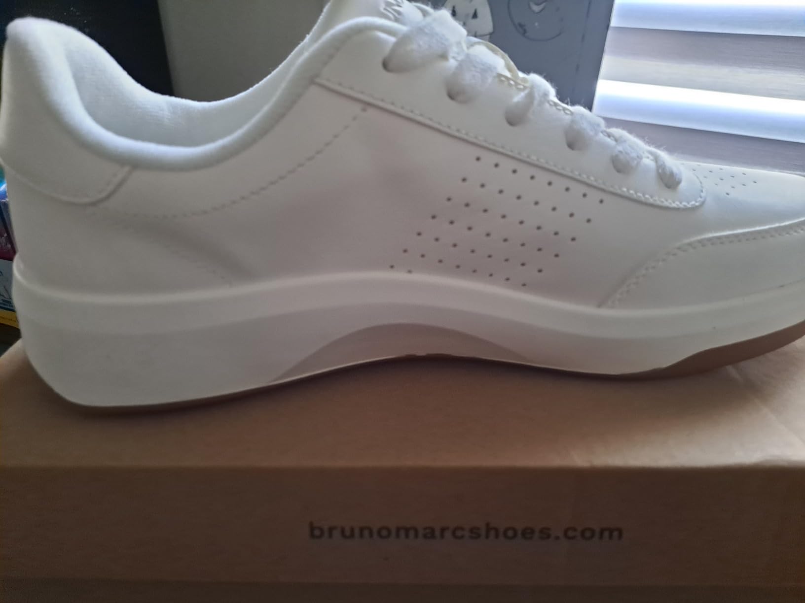 Close-up of Bruno Marc sneaker construction showing perforated leather upper and padded collar details