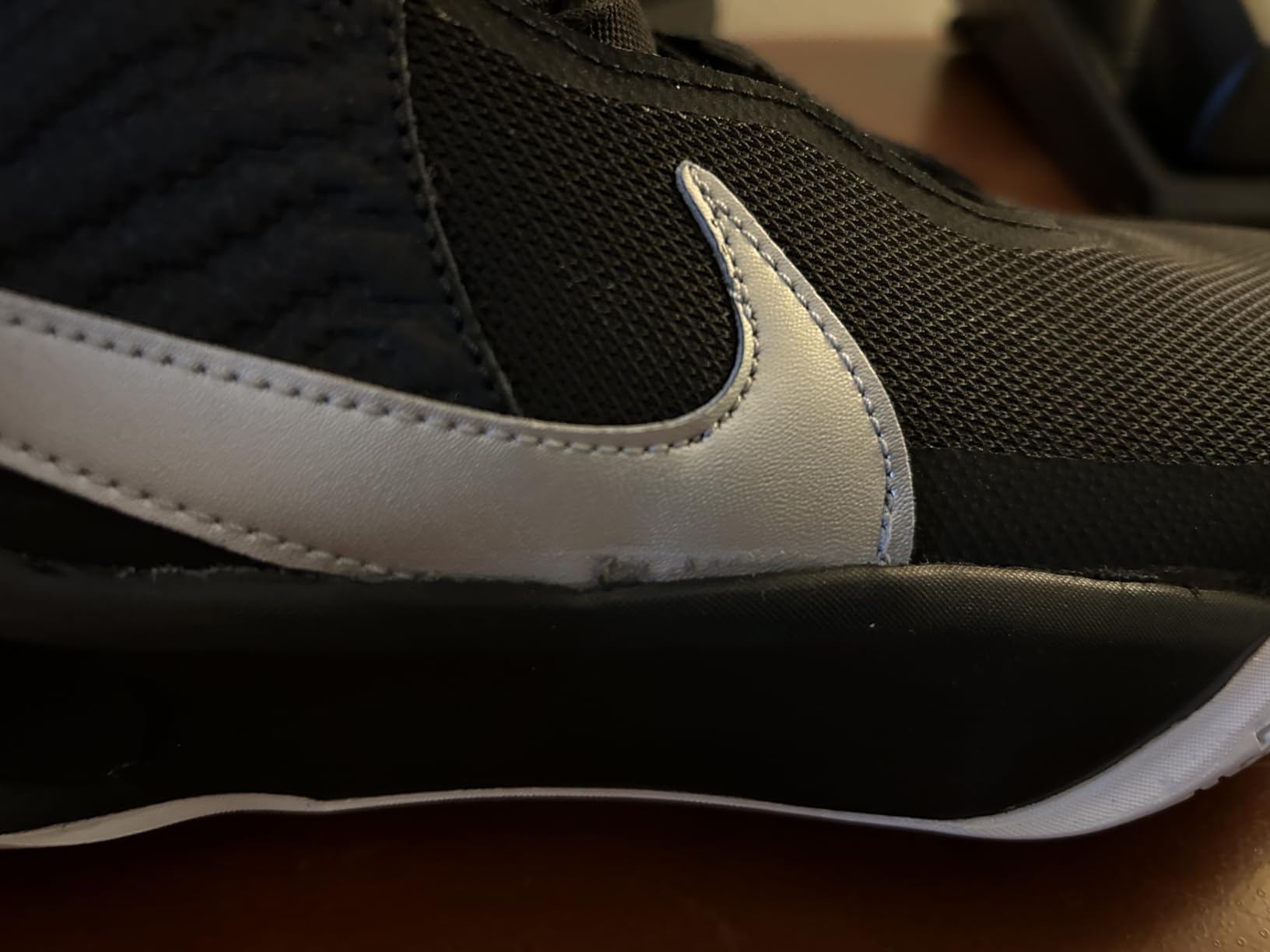 Nike Team Hustle D 10 showing quality defect with damaged swoosh logo