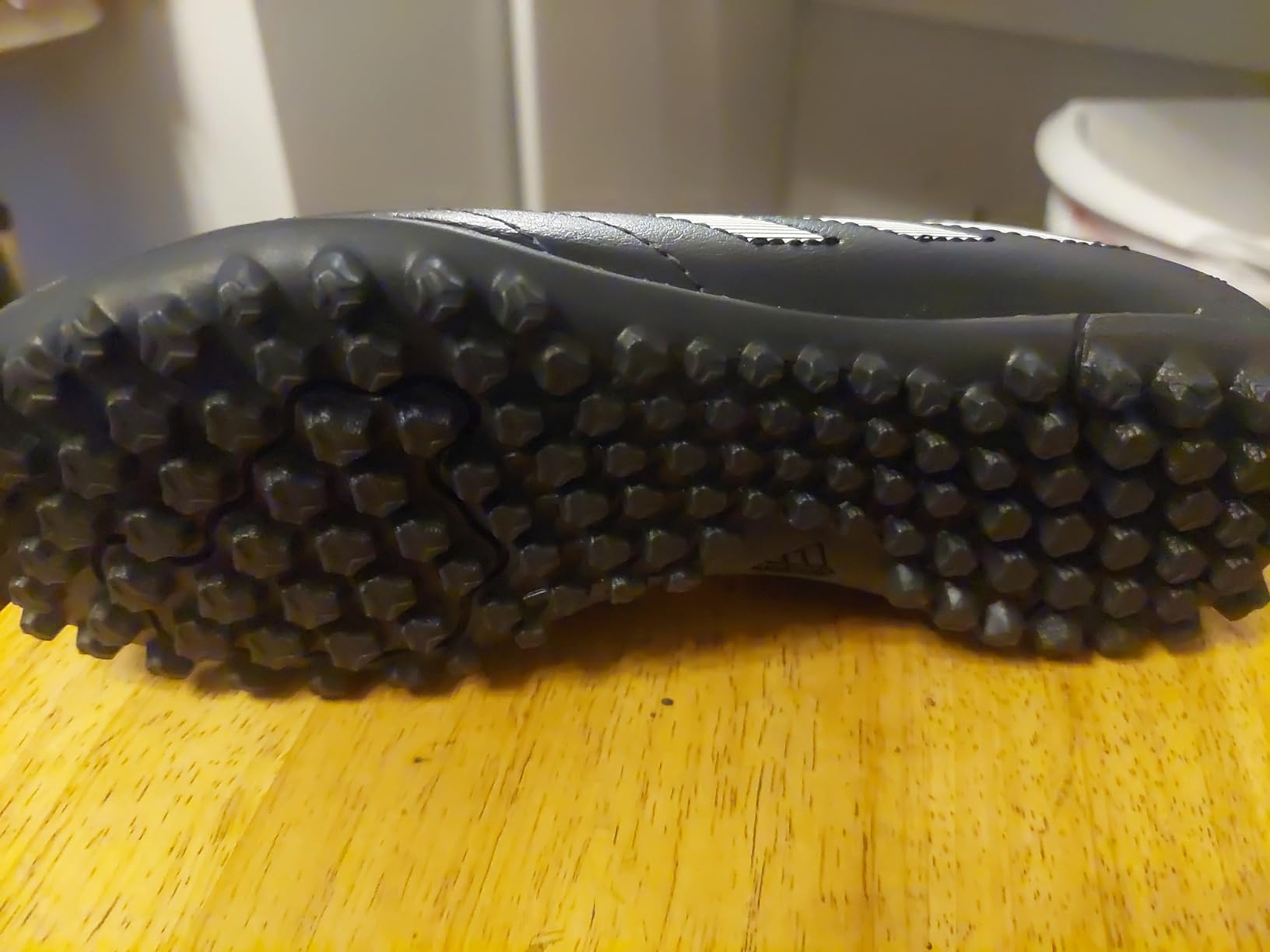 Close up of adidas Kids Goletto turf shoe showing lacing system and synthetic upper detail