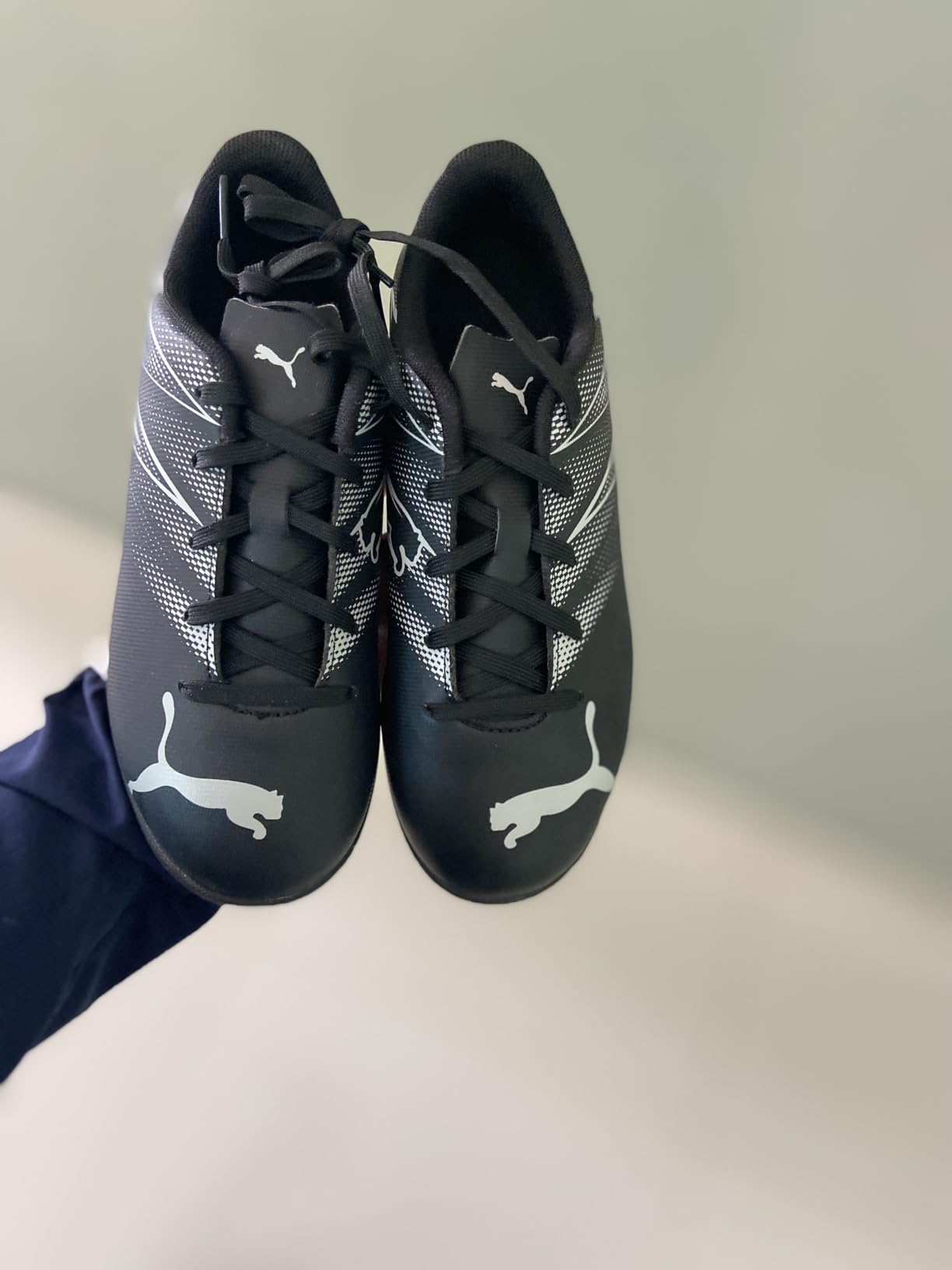 Close-up of PUMA Attacanto soccer cleat showing synthetic upper material and turf sole pattern