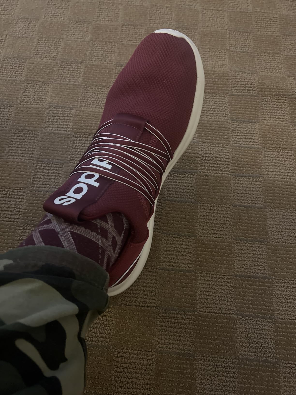 Close-up of Adidas Lite Racer Adapt 7.0 showing textile upper construction and lace system detail