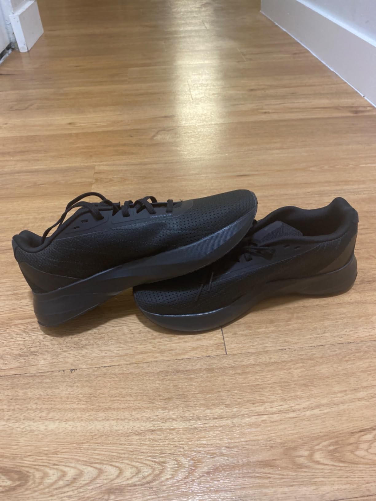 Adidas Duramo SL black colorway on foot showing sleek athletic profile