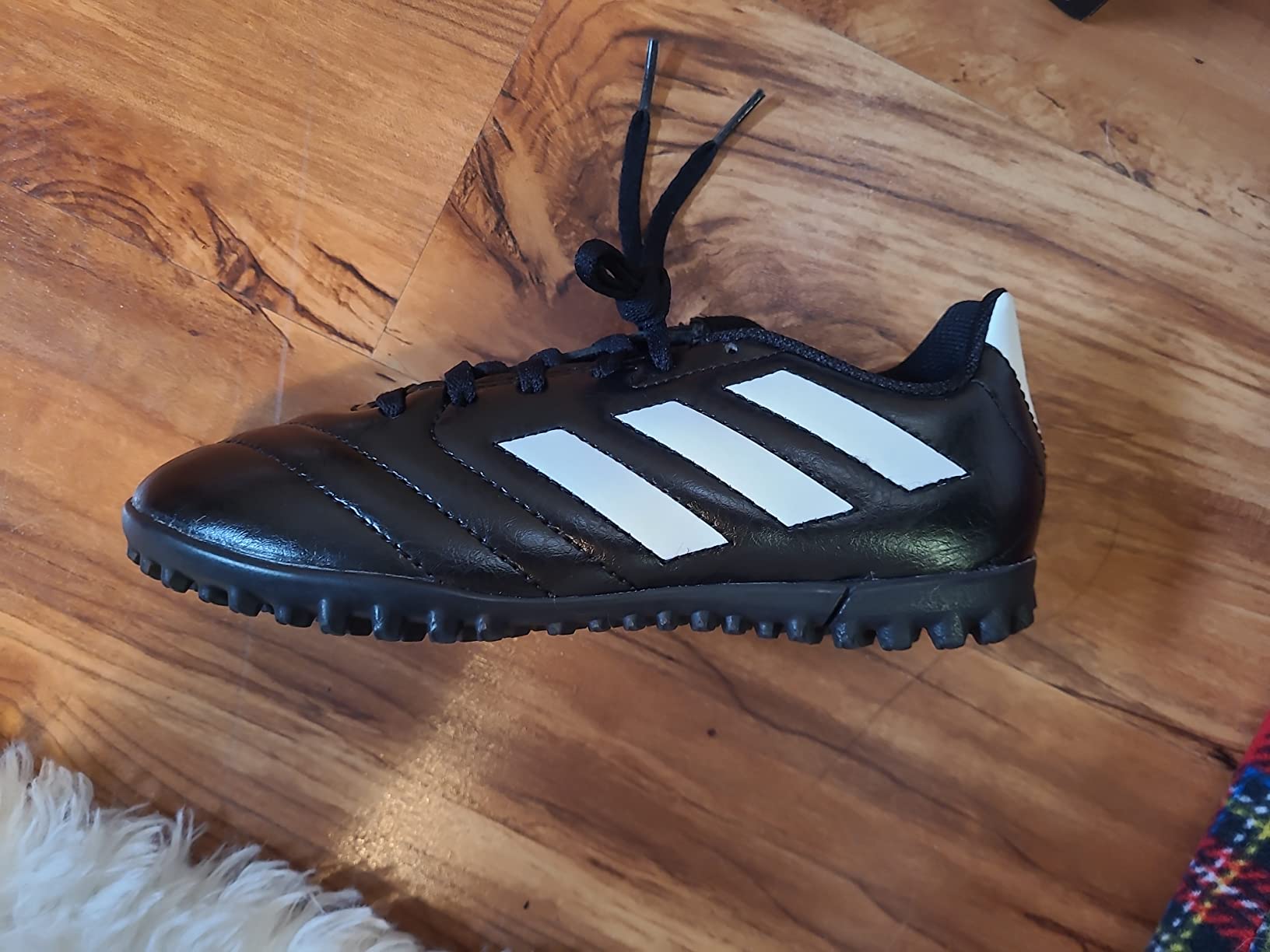 Adidas Kids Goletto shoe close-up showing synthetic upper and branding details