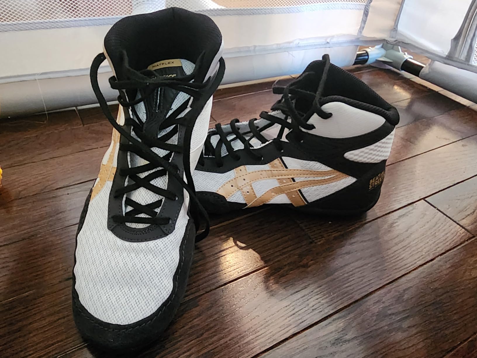 ASICS Matflex 7 black and gold colorway showing durability after extended wrestling use