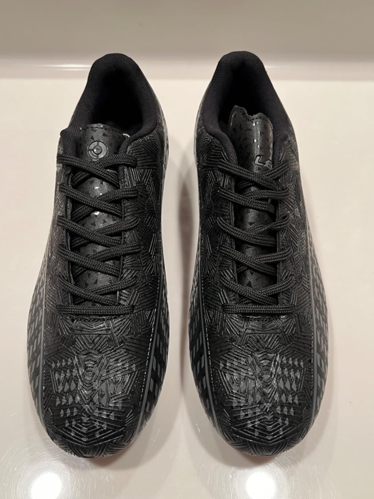 Soccer cleats detail shot showing synthetic upper texture and lacing system