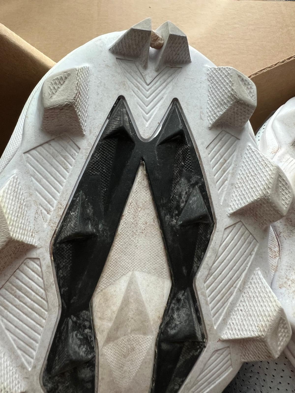 Close-up view of Under Armour football cleat construction showing mesh upper and molded sole pattern