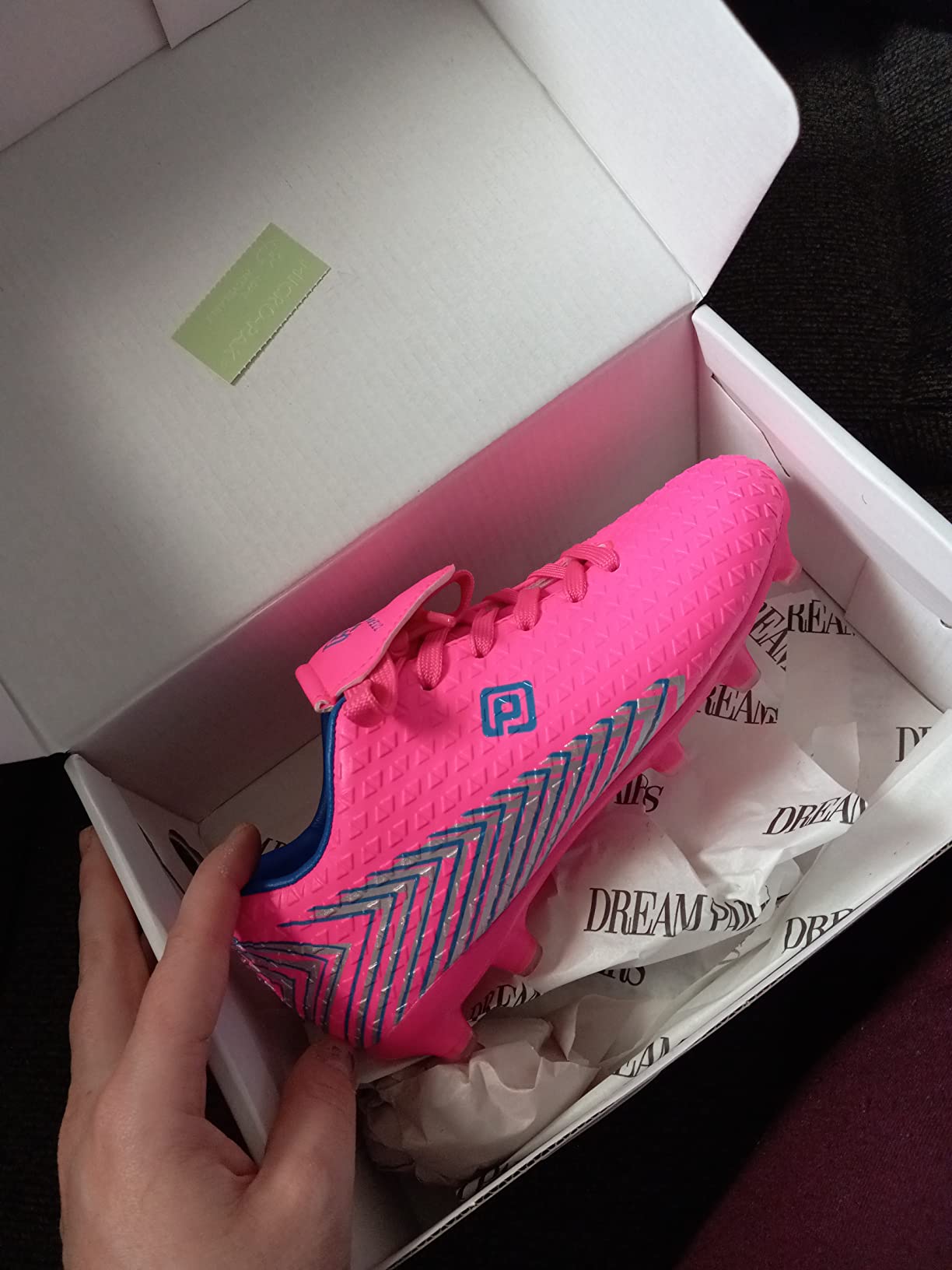 Close-up view of DREAM PAIRS soccer cleat sole showing TPU stud pattern and grip design for firm ground play