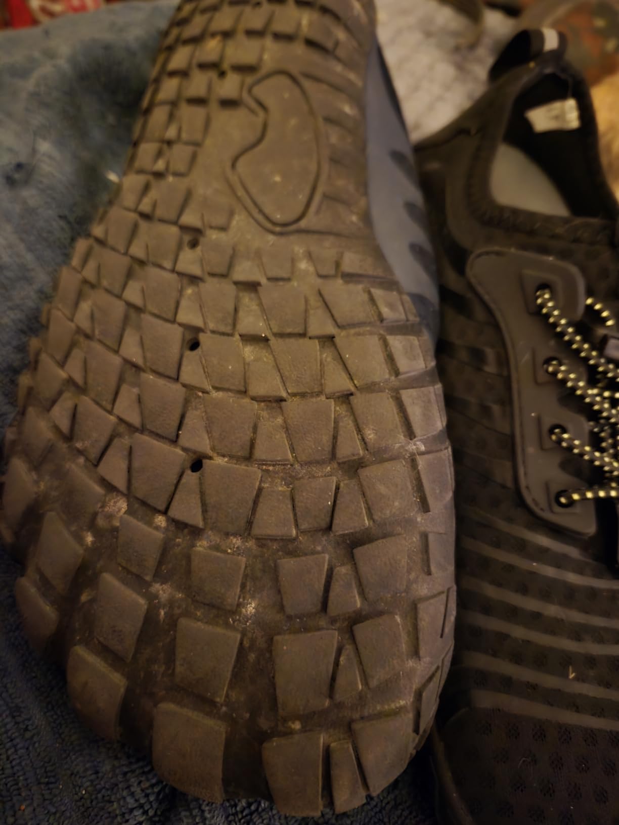 Rubber sole showing drainage holes and anti-slip tread pattern for traction