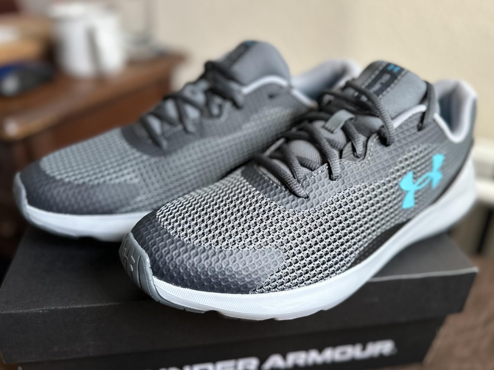 Under Armour Men's Surge 3 Running Shoe black colorway showing mesh upper and EVA midsole design