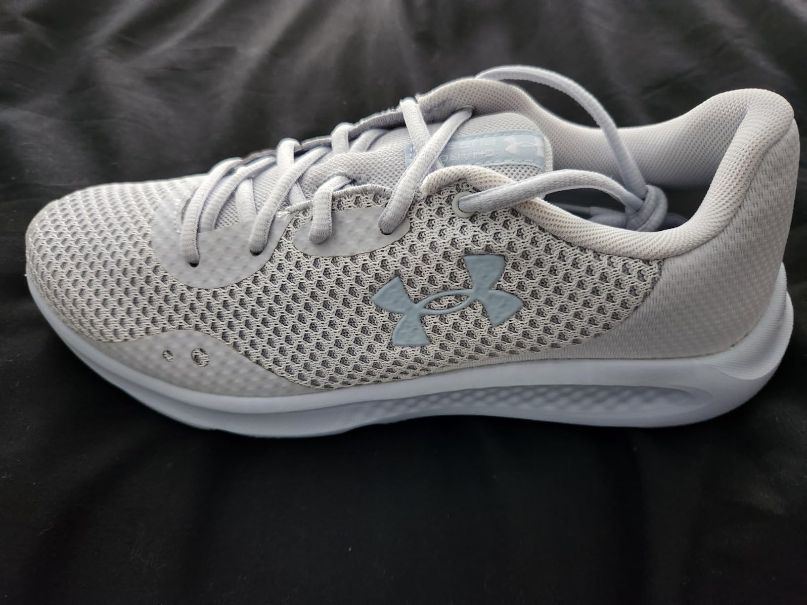Under Armour Charged Pursuit 3 in light grey colorway showing clean aesthetic design