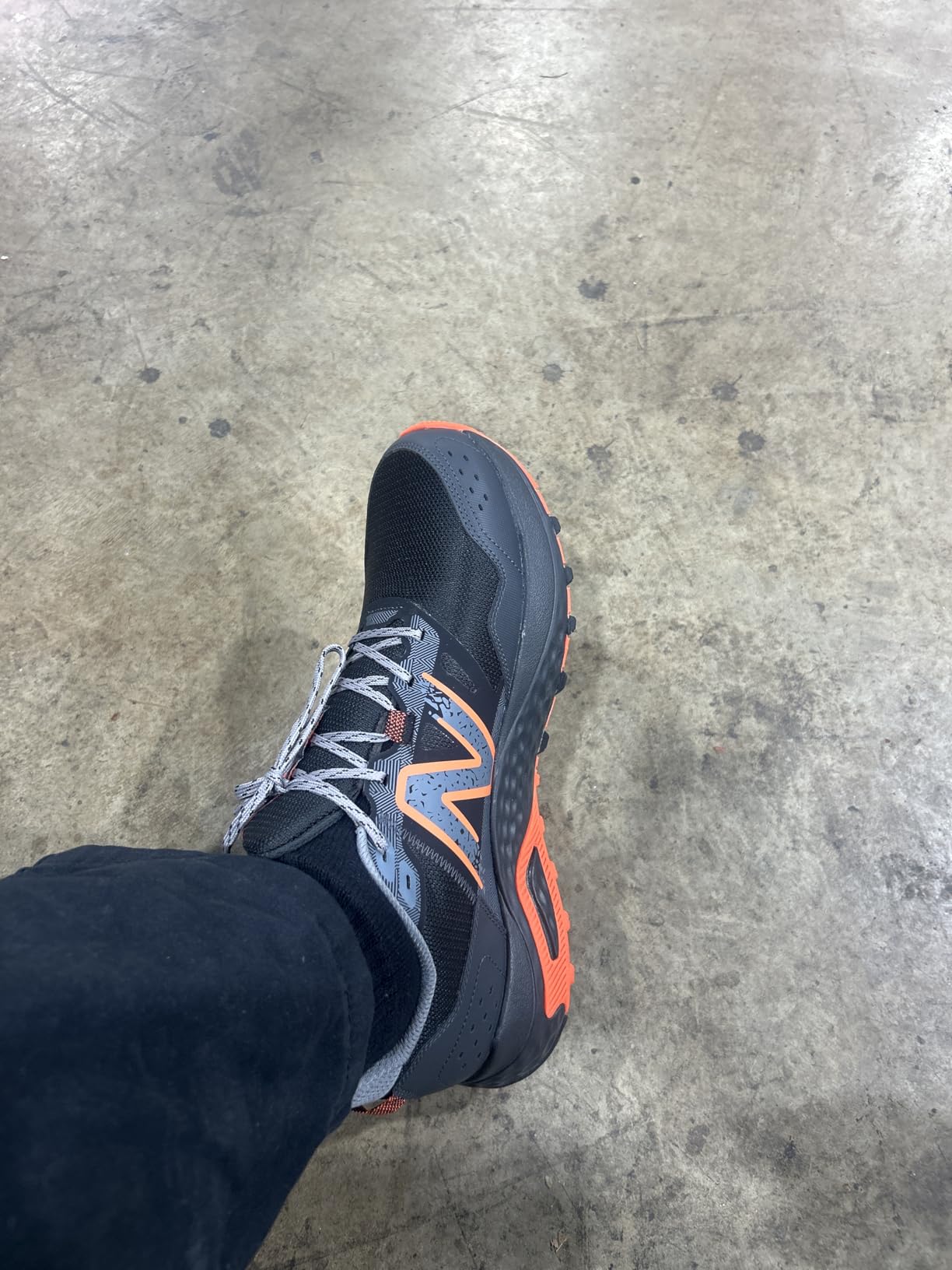 New Balance MT410V8 showing orange and black colorway with trail-ready design features