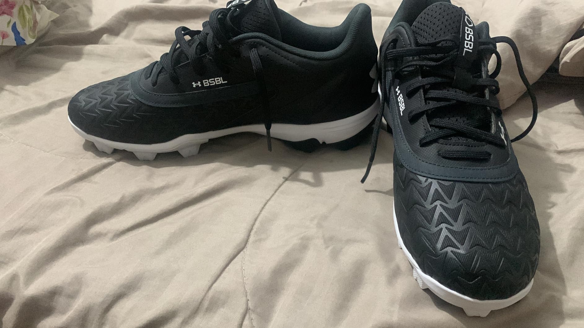 Under Armour Leadoff Low RM 3.0 on grass baseball field showing molded cleat traction pattern
