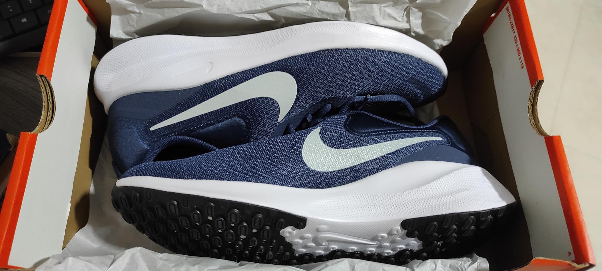 Nike Revolution 7 midsole showing EVA foam cushioning and heel padding details