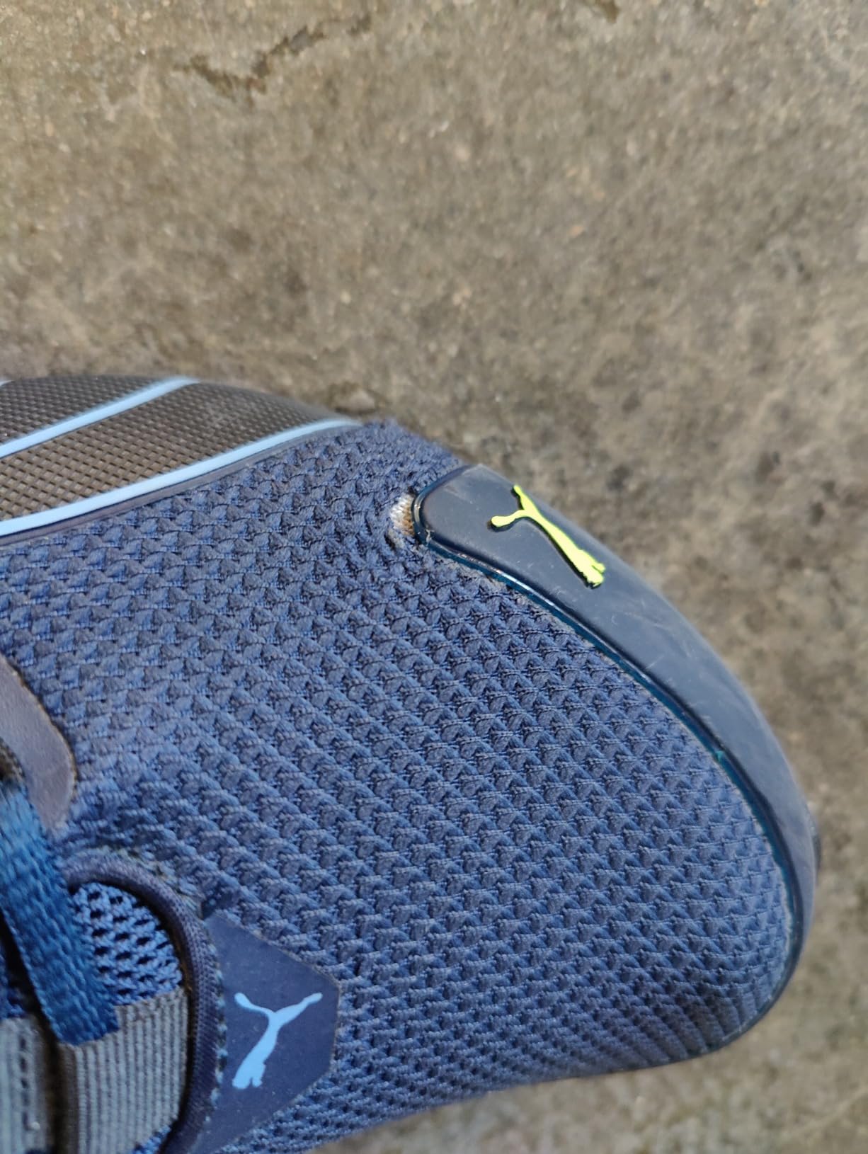 Close-up of PUMA Voltaic Evo mesh panel showing typical wear pattern and stress points