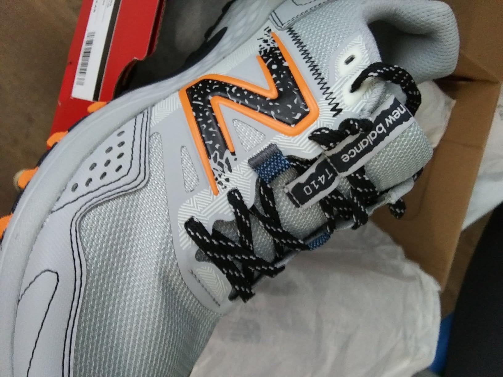 Close-up of New Balance MT410V8 synthetic upper construction showing mesh panels and overlay design