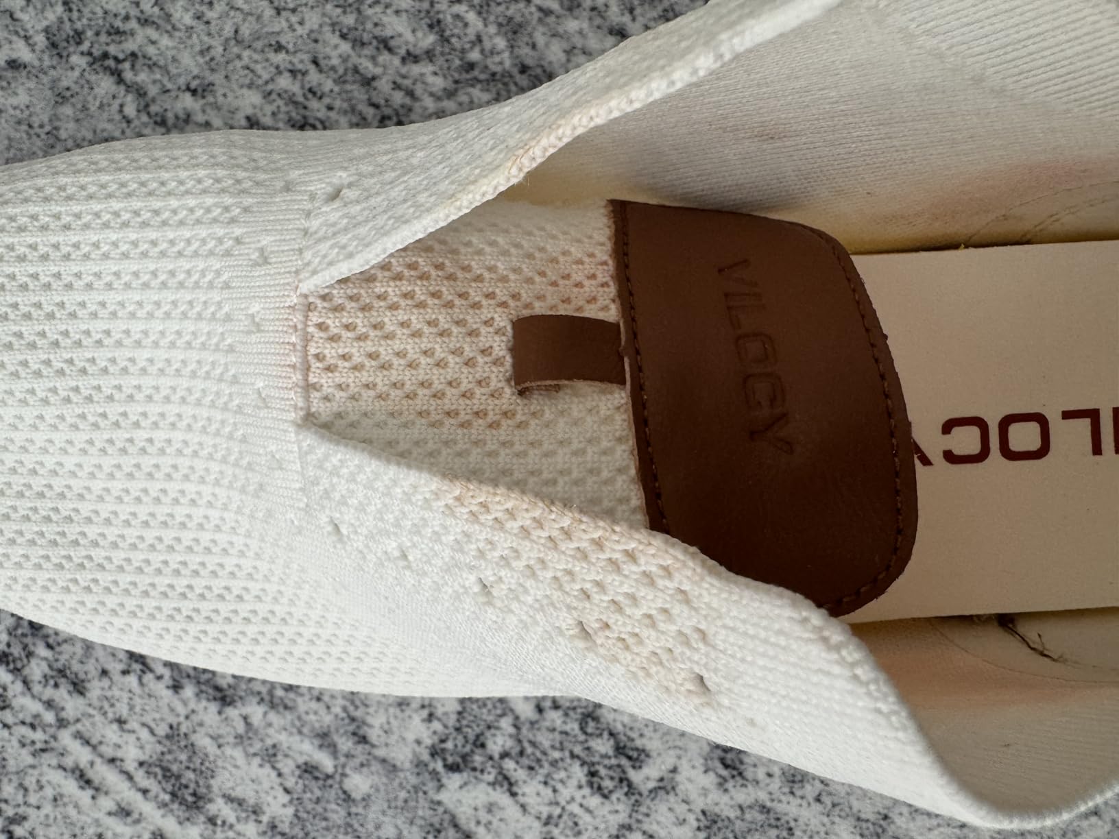 Water damage showing leather bleeding issue affecting white portions of shoe