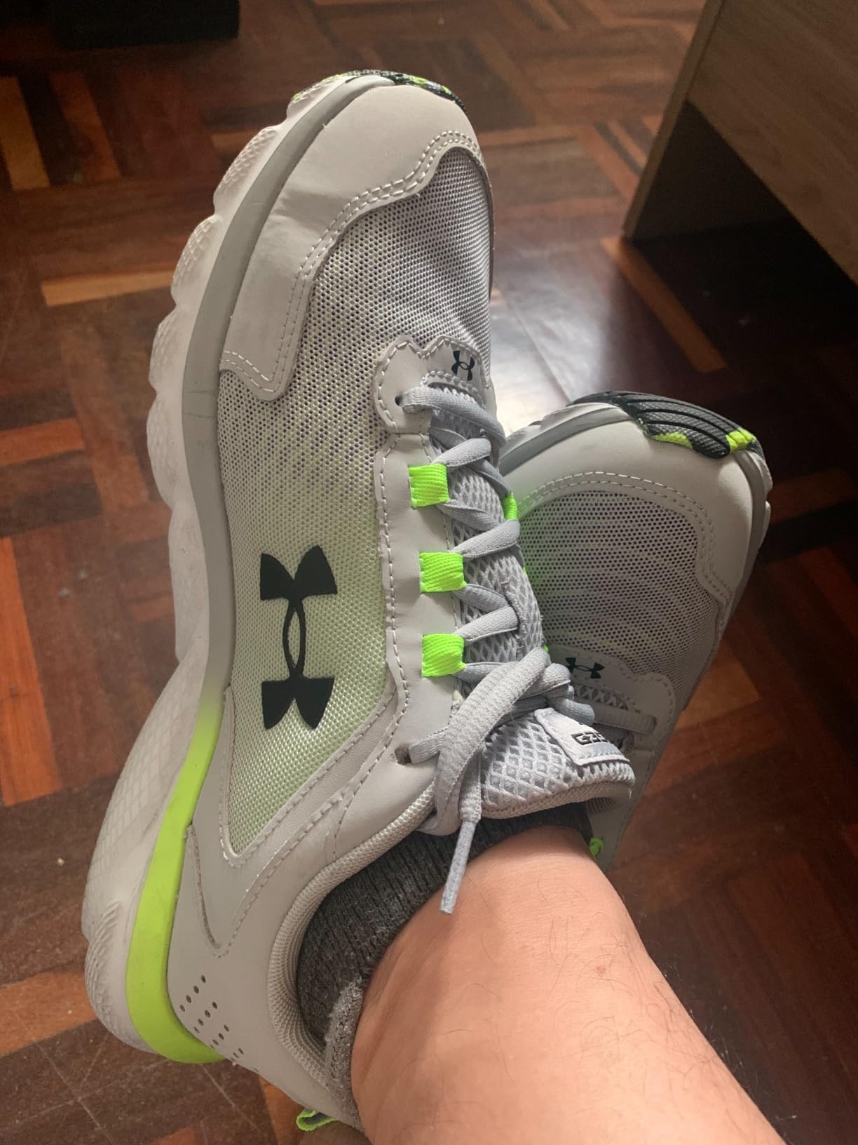 Under Armour Charged Assert 9 black and blaze orange colorway showing mesh upper and Charged Cushioning technology