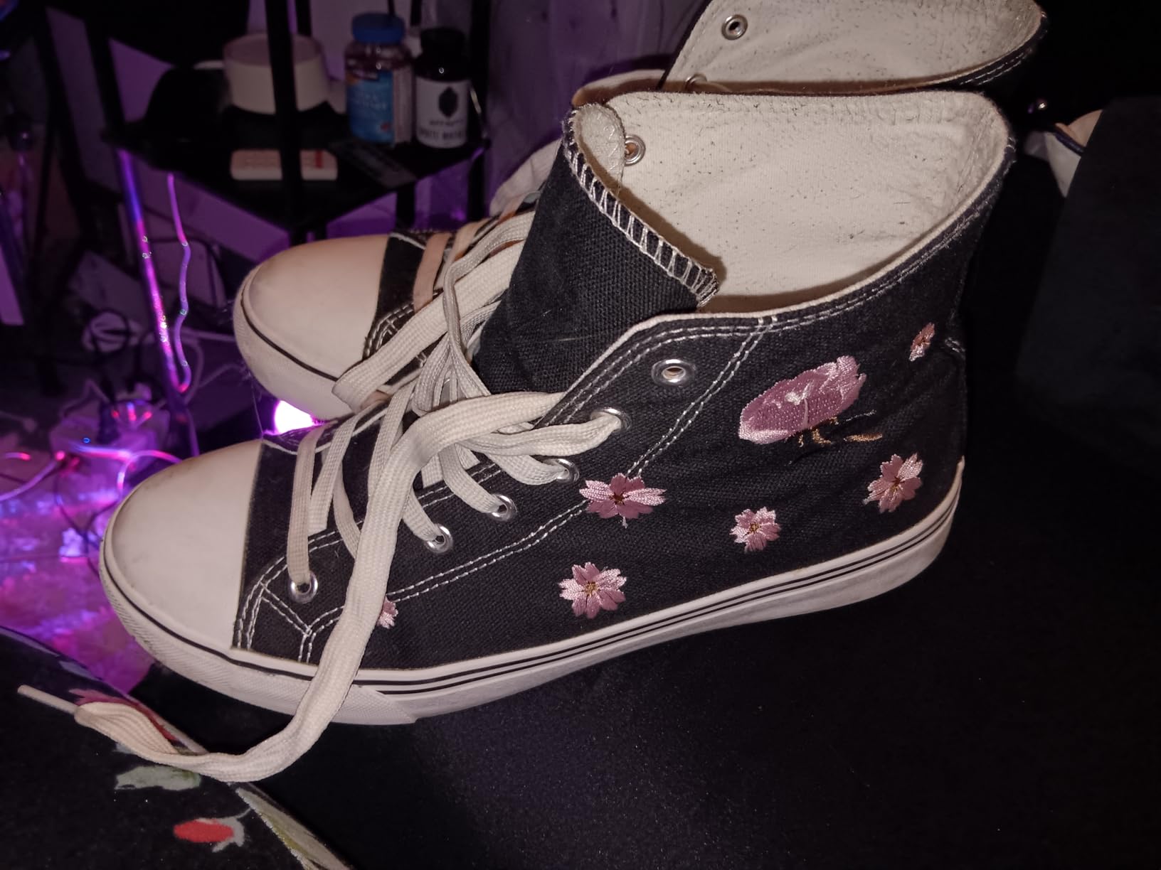Close-up view of kufeiti canvas sneakers showing detailed floral embroidery pattern and lace-up design