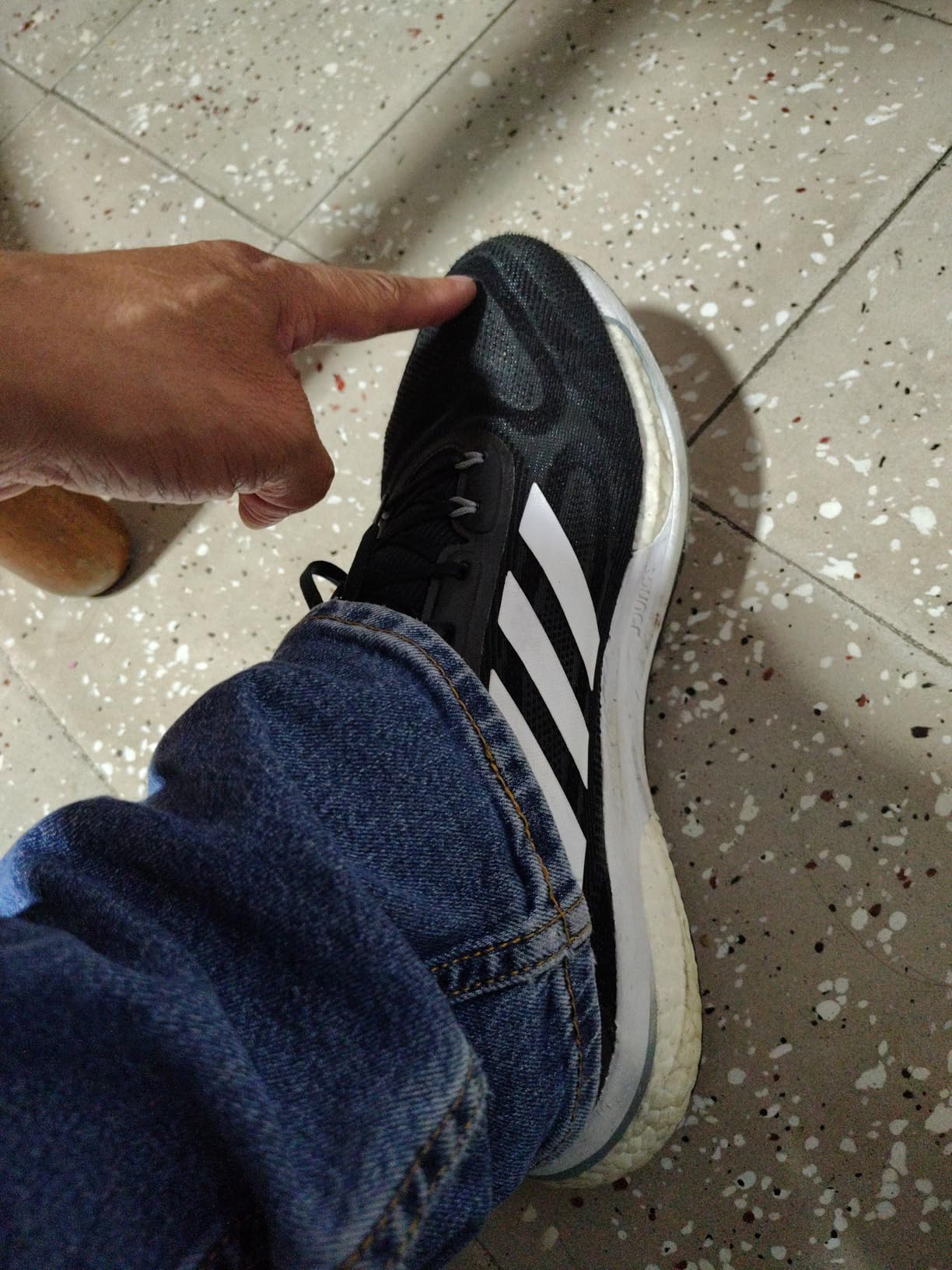 Adidas Men's Supernova running shoe showing hybrid midsole technology and mesh upper design