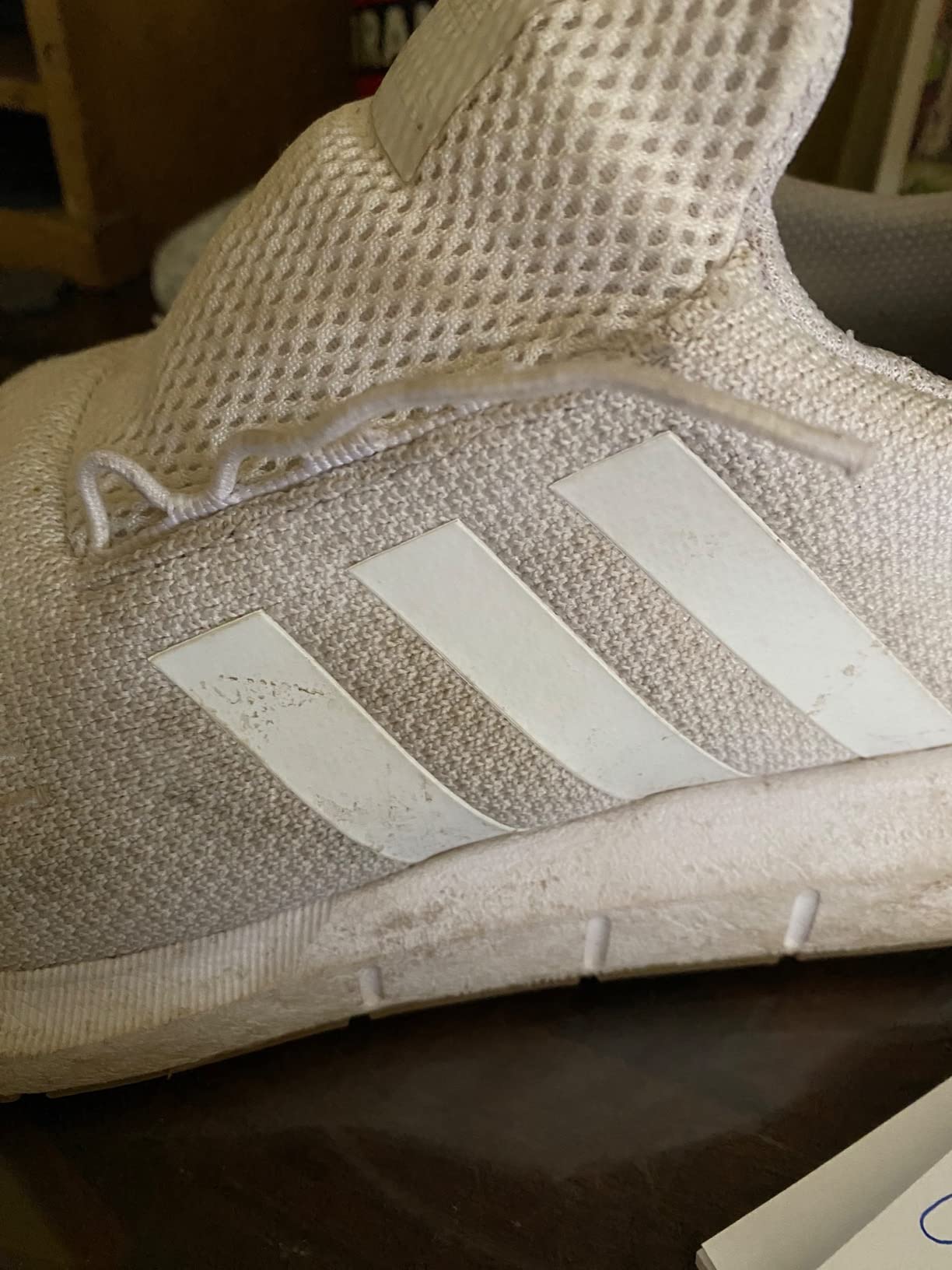 Close-up showing broken lace eyelet on Adidas Swift Run after normal use