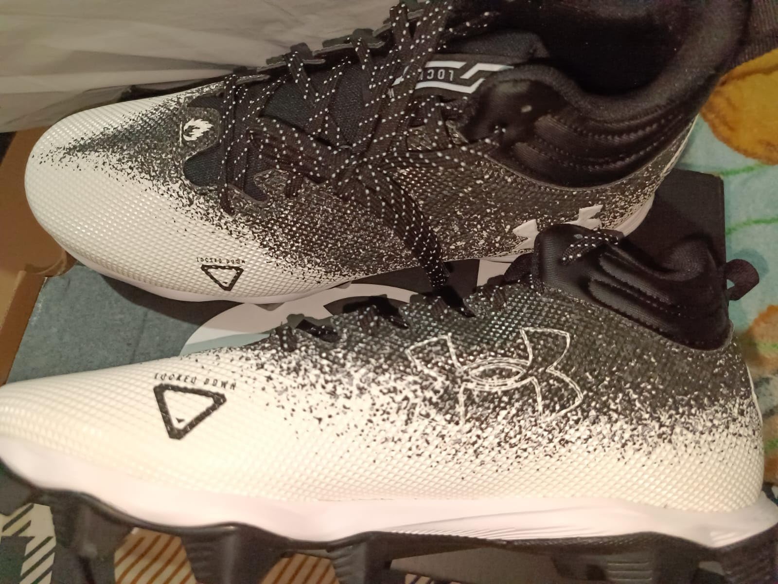 Under Armour Spotlight Fran 2.0 football cleats black colorway showing high ankle design and molded rubber cleat pattern