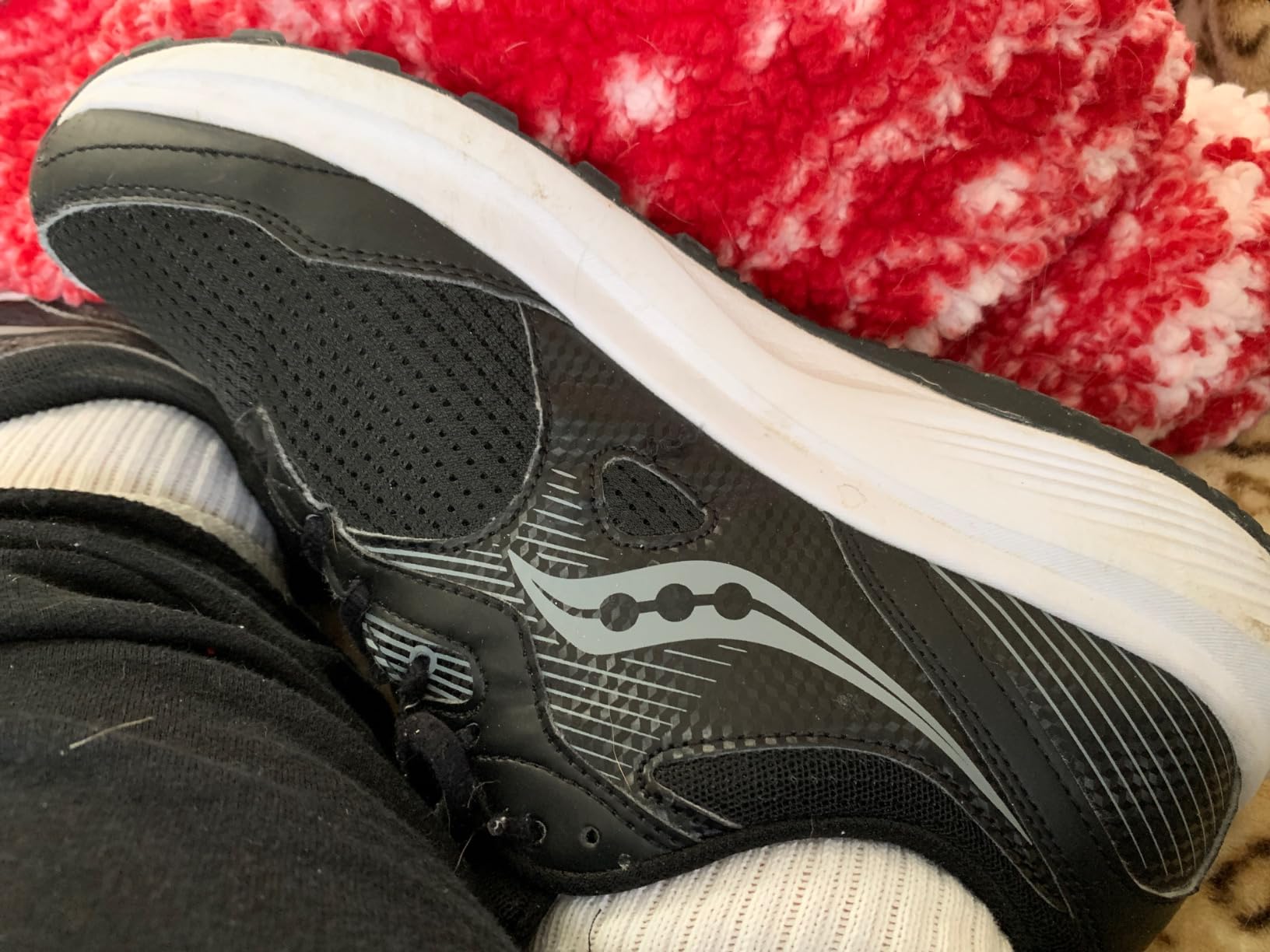 Saucony Men's Cohesion 13 running shoes in dark grey and orange colorway showing mesh upper and VersaFoam sole