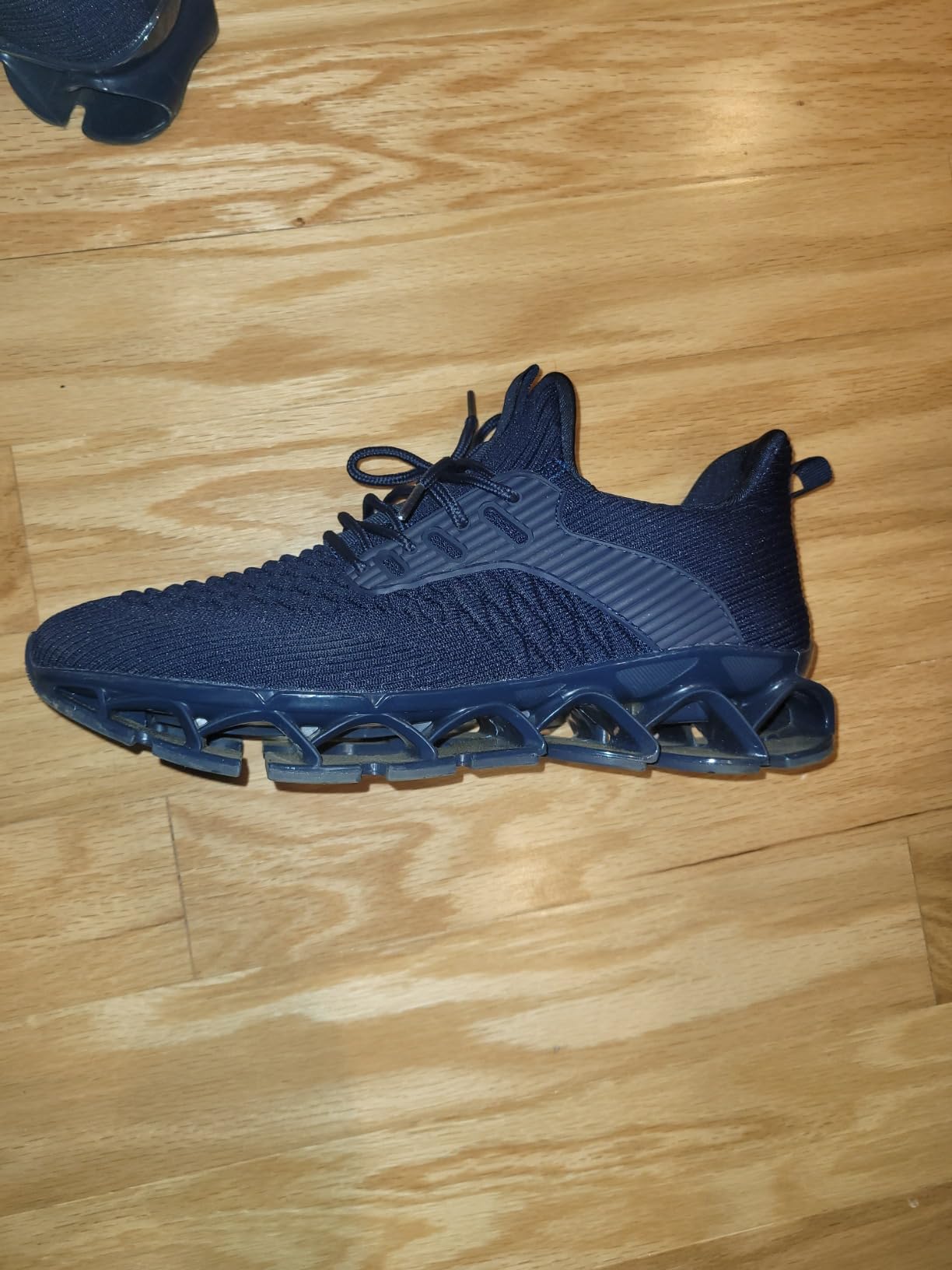Side profile view of mens blade sneakers showing the distinctive lattice sole from ankle perspective