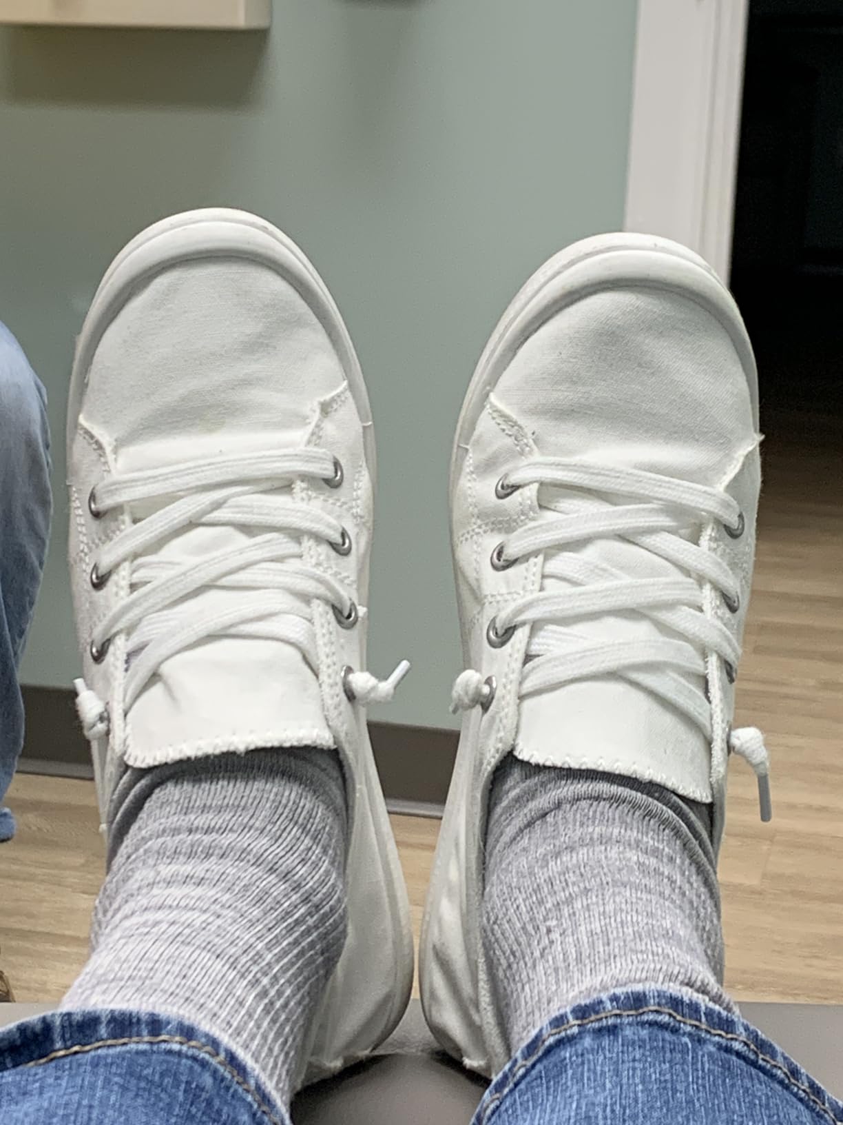 White canvas sneakers on feet showing true-to-size fit and comfortable casual appearance
