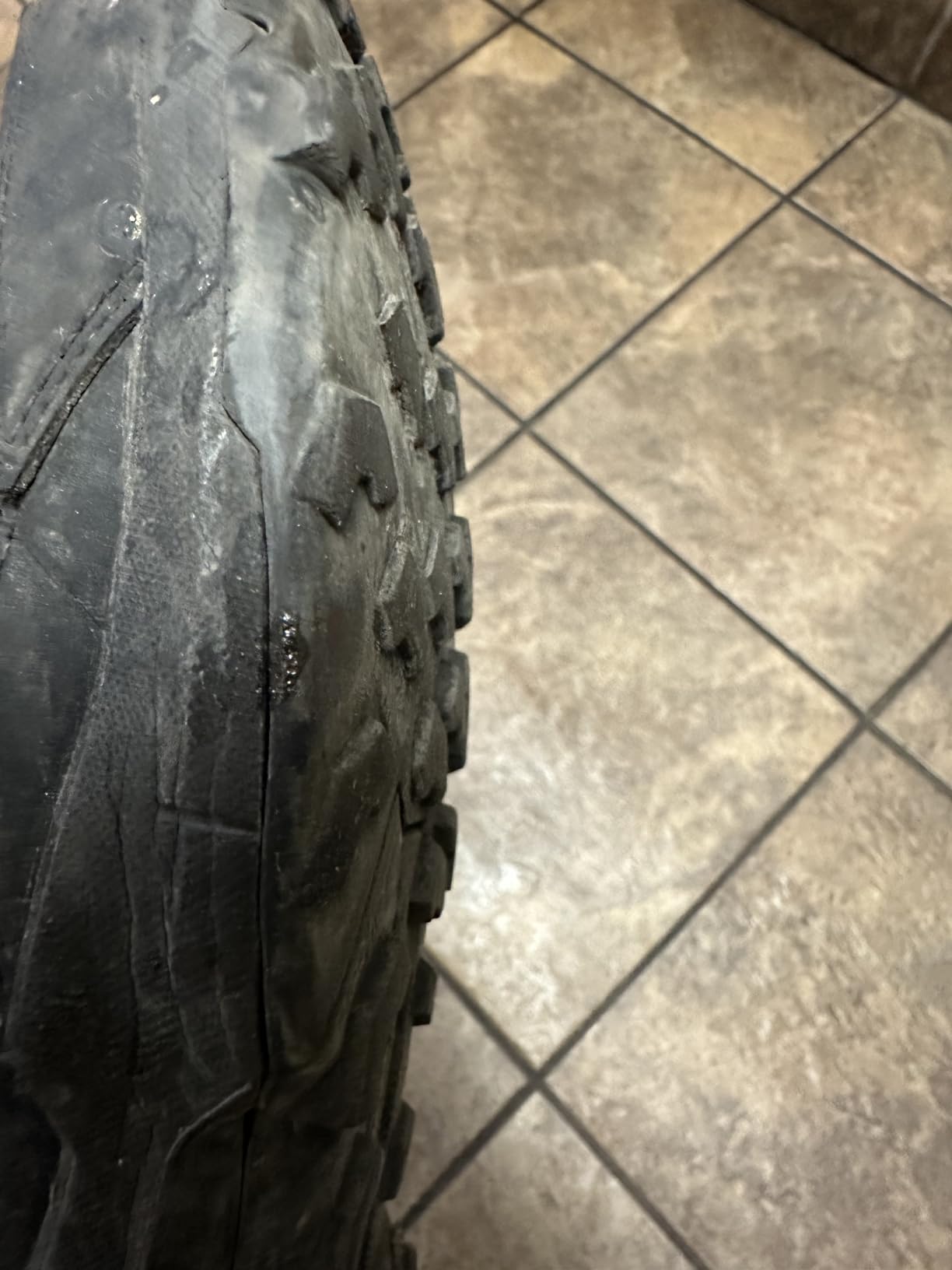 Bottom view of worn Adidas Terrex AX4 showing tread wear pattern after extended use