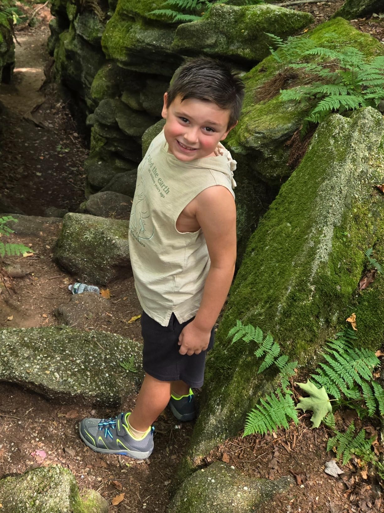 Young hiker wearing Merrell Trail Chaser shoes on rocky terrain showing real-world trail performance