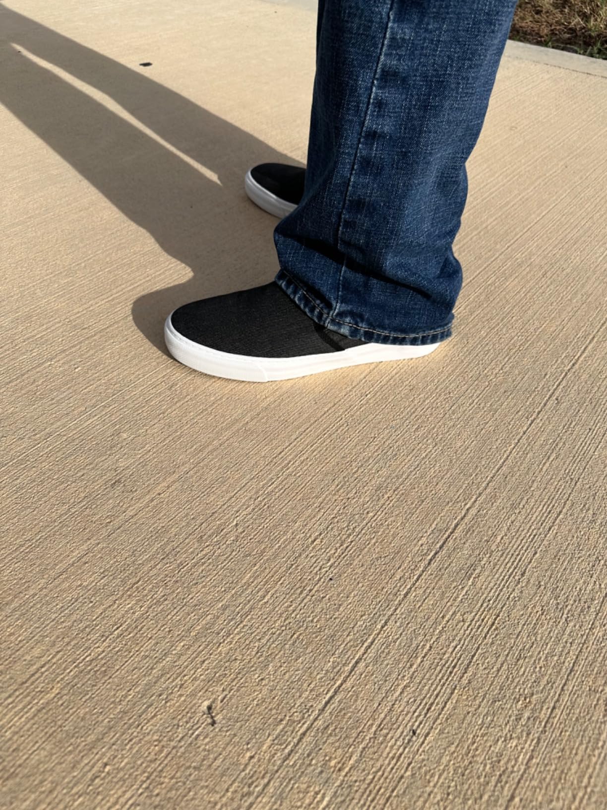 Close up view of canvas slip-on sneakers showing elastic side panels and vulcanized sole construction
