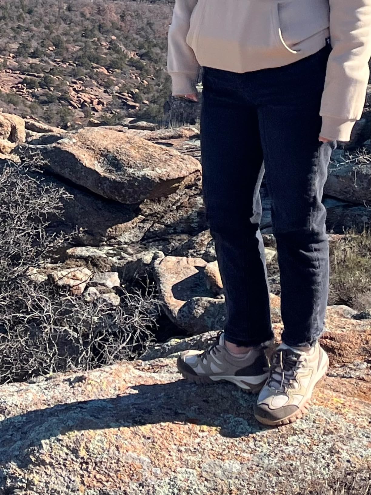 Hiking shoes on rocky mountain trail showing tread pattern and grip performance