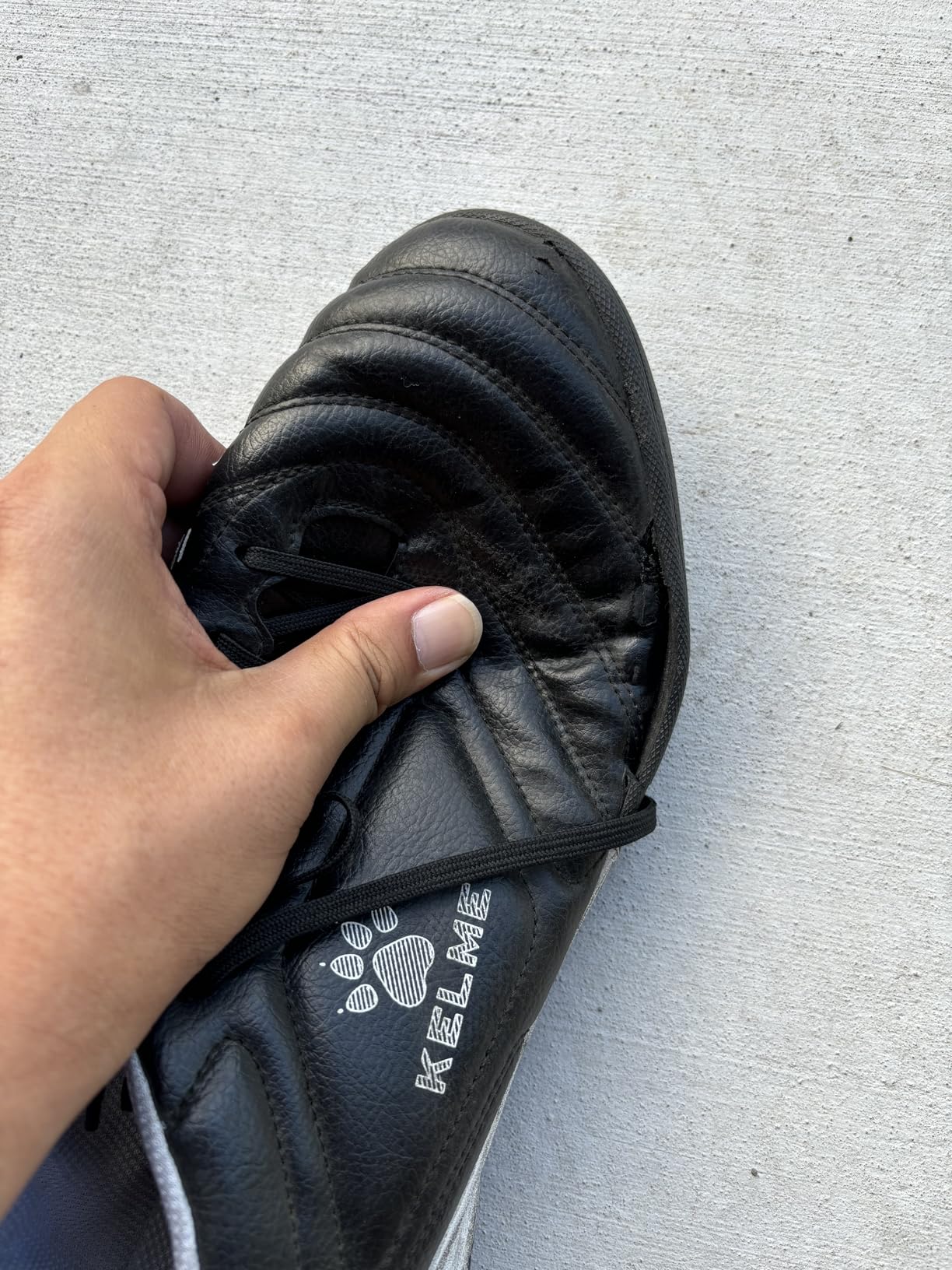 Close-up of KELME cleat showing side material separation and wear patterns after 6 weeks testing