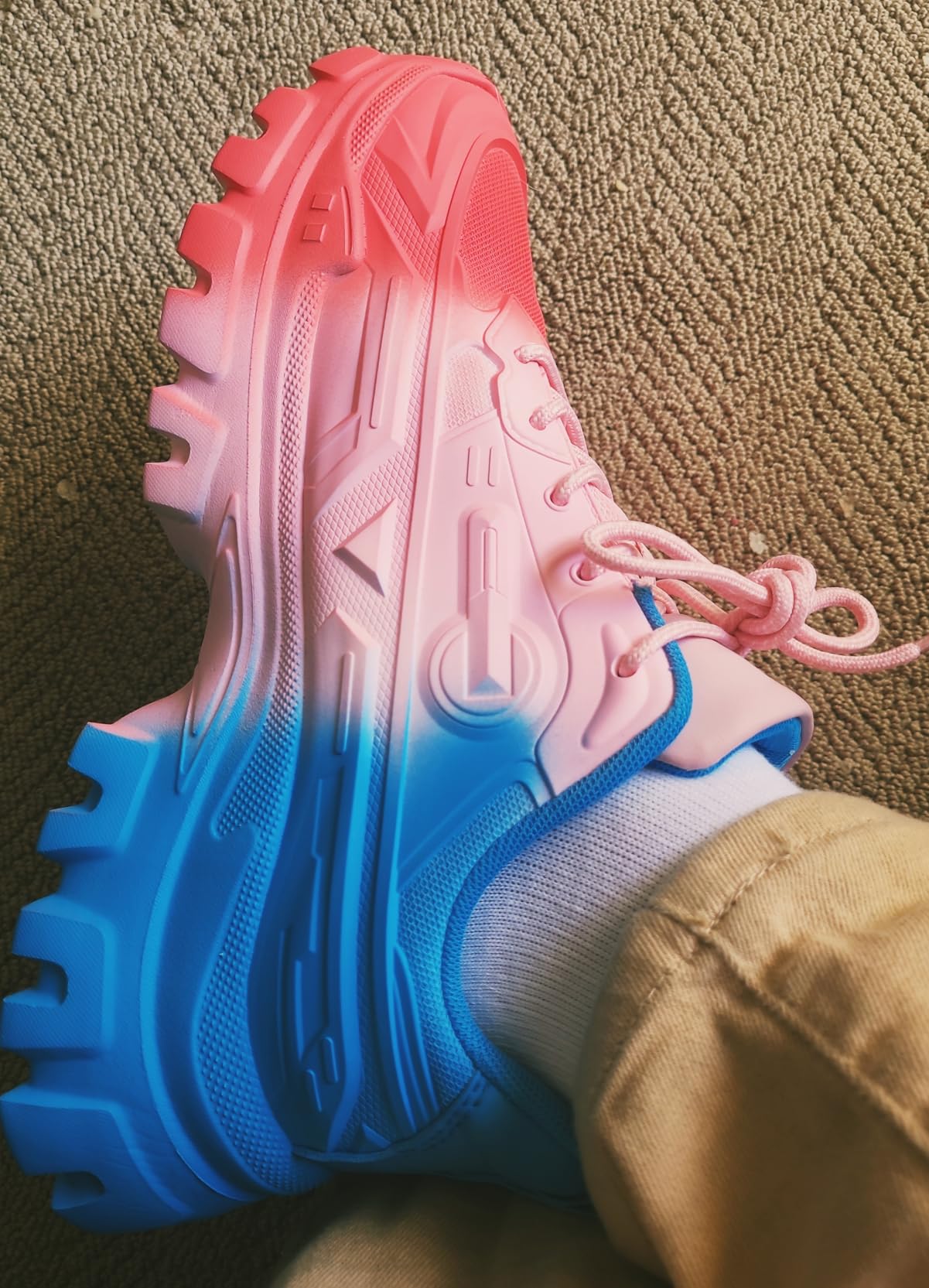 Side profile showing chunky platform sole and layered design elements of white sneakers