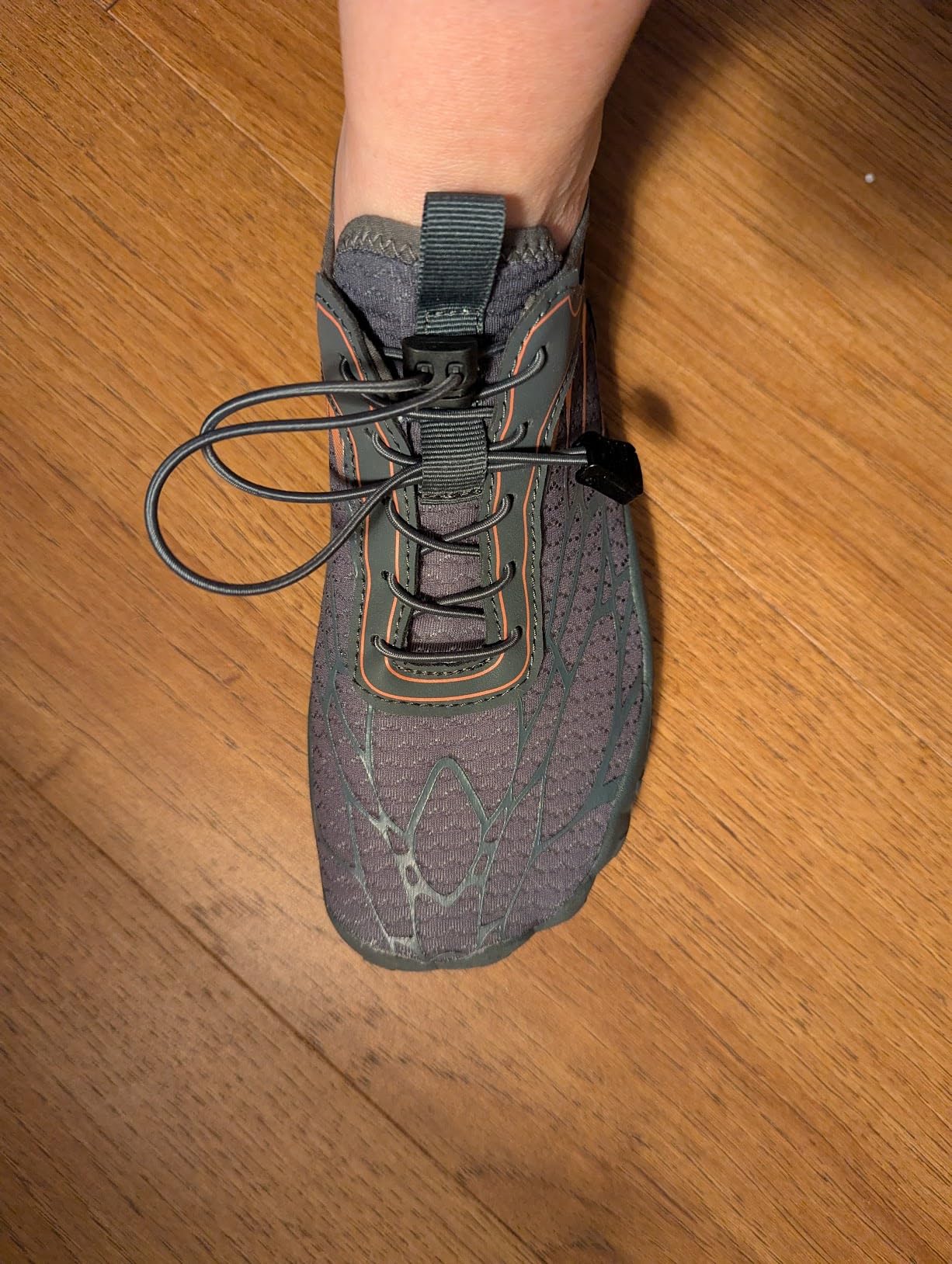 Close-up view of barefoot shoe construction showing elastic lacing system and mesh upper material