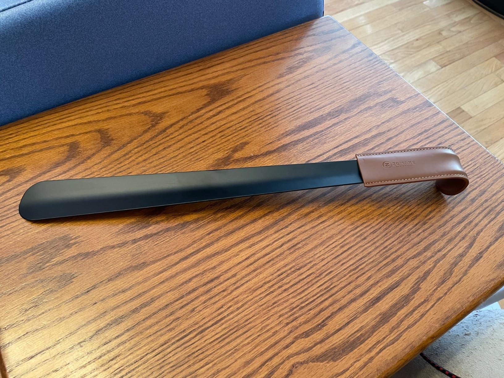 Close-up of ZOMAKE shoe horn construction showing metal finish and leather handle detail