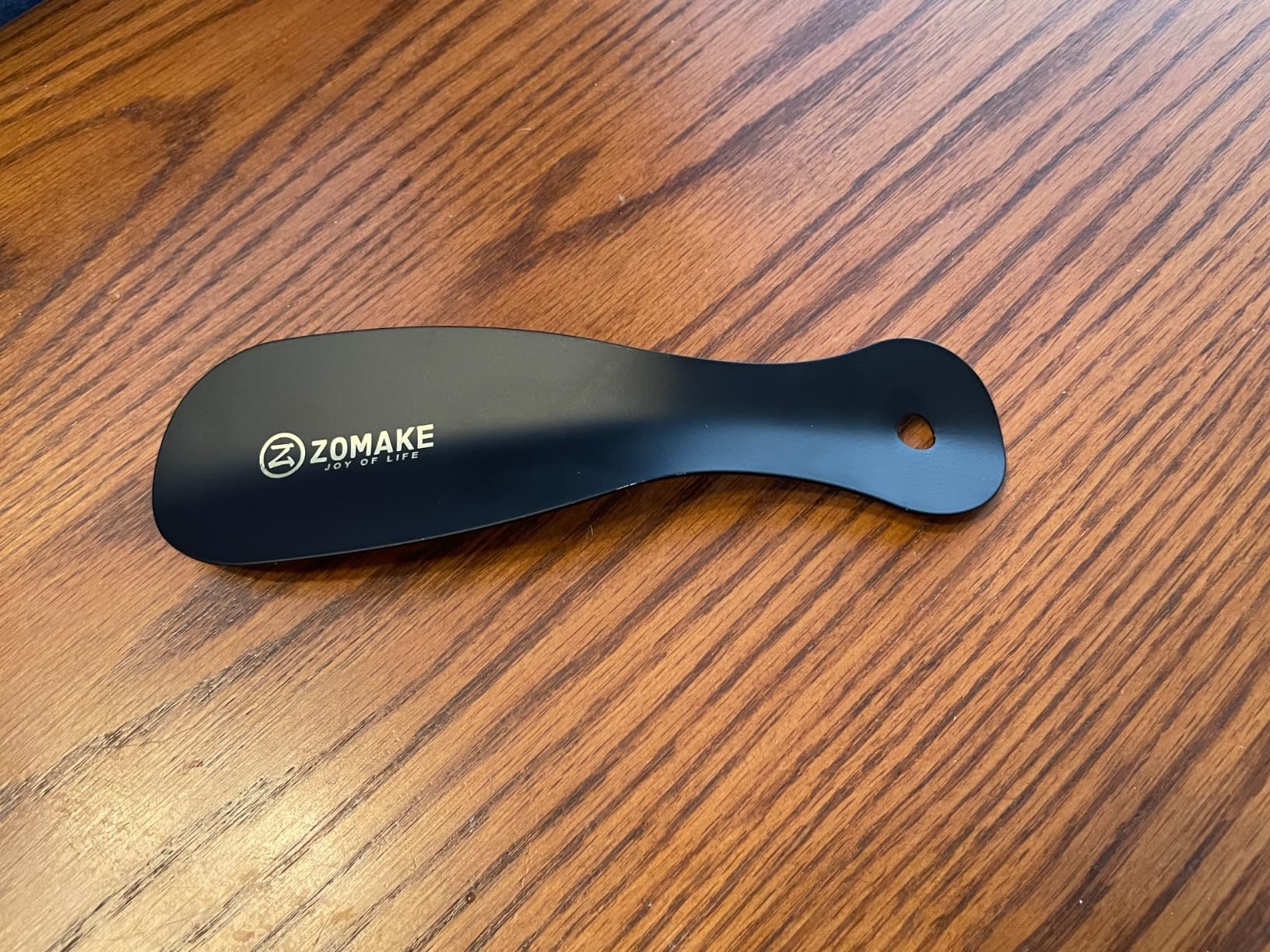 ZOMAKE shoe horn being used with different shoe types showing versatility