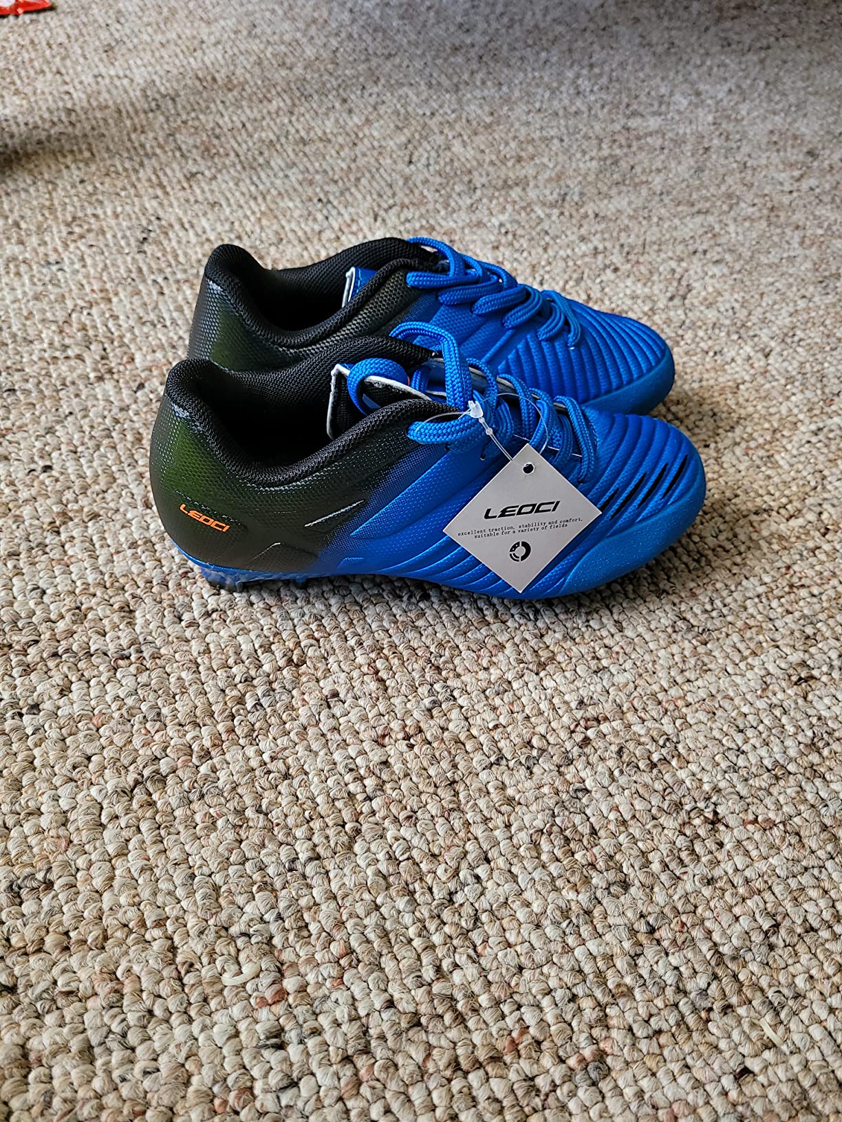 Close-up of LEOCI soccer cleat showing textured upper material and lace-up design details