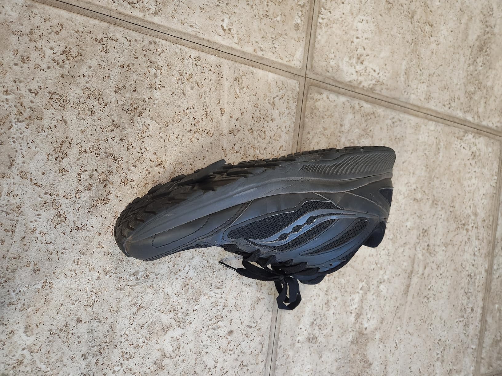 Saucony Cohesion 14 Trail in action on rocky terrain showing grip and stability performance