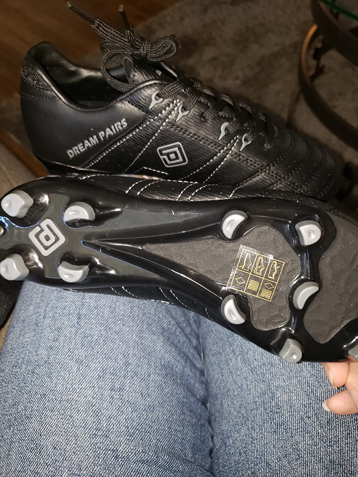 Bottom view of DREAM PAIRS cleats showing molded stud configuration for multiple surfaces