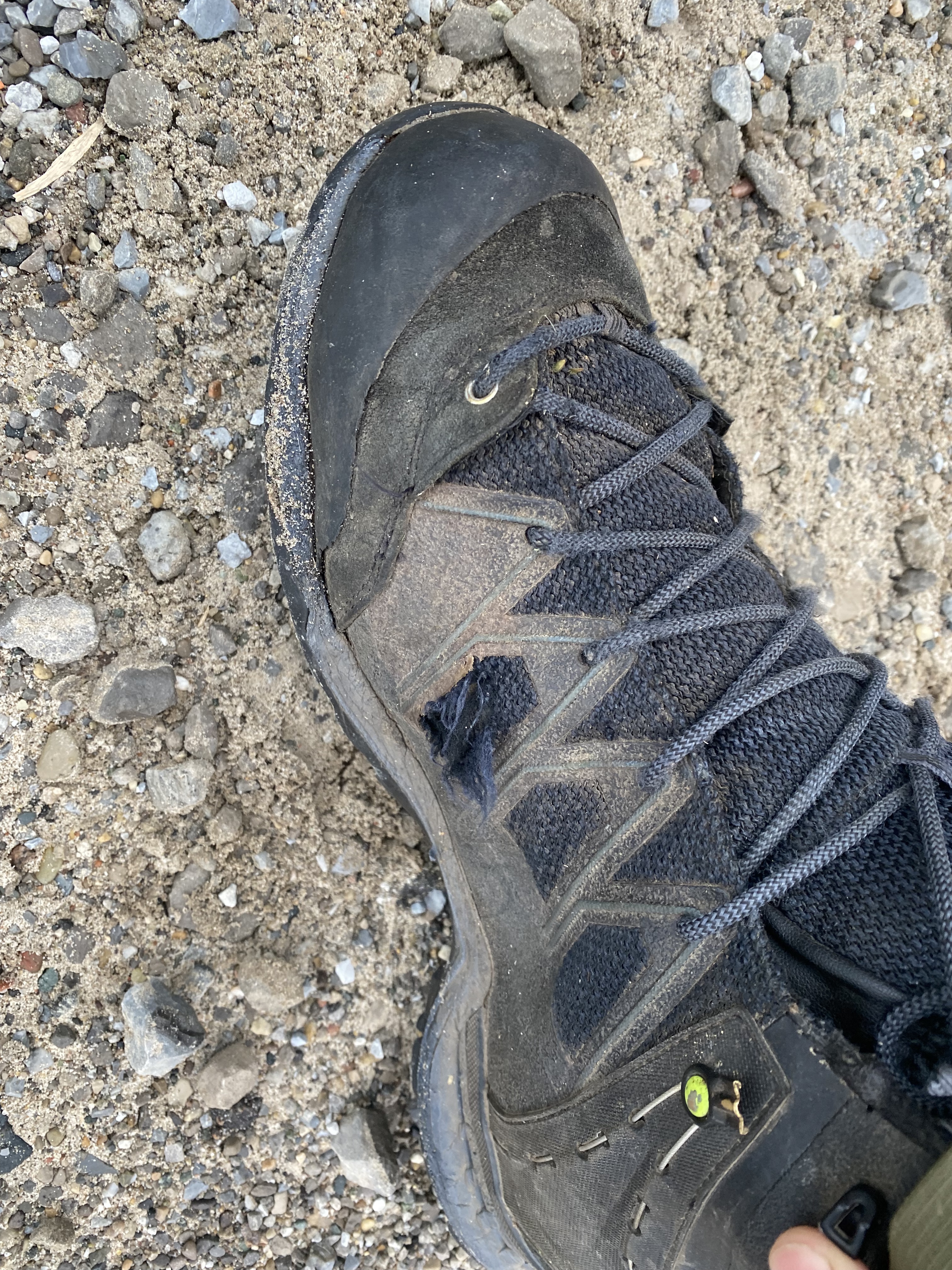 Broken lace hook showing plastic hardware failure point on hiking boot