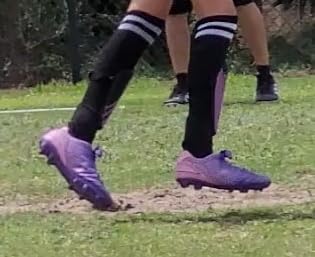 DREAM PAIRS cleats being tested on different field surfaces showing versatility