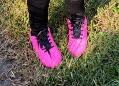 BomKinta soccer cleats in bright pink colorway showing FG stud pattern for grass fields