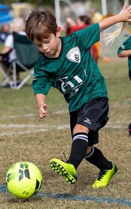 Action shot of young player in bright yellow Vizari Stealth cleats during game play
