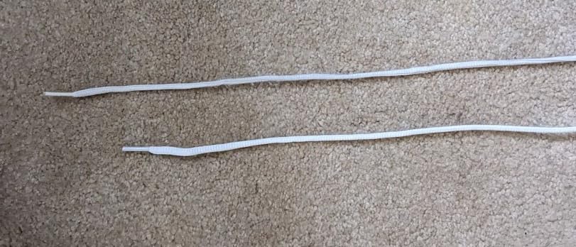 Close-up of ASICS Upcourt 5 lacing system showing notably short shoelaces